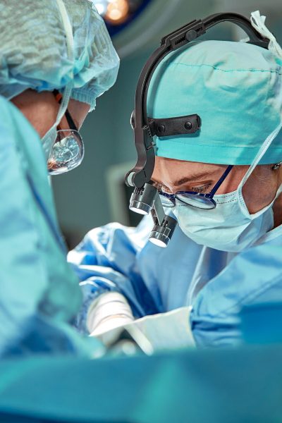 Group of surgeons looking at patient on operation table during their work Group of surgeons looking at patient on operation table during their work.